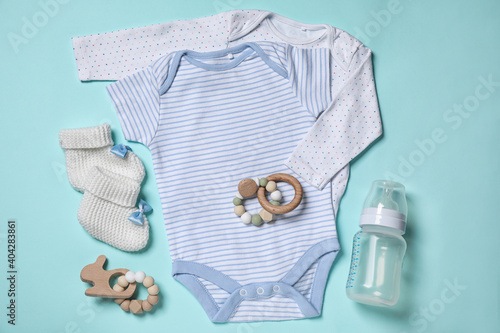 Flat lay composition with cute baby items on cyan background