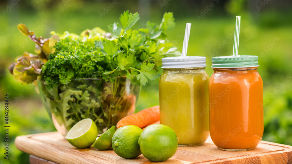 Two natural drinks on the table next to a set of fruits and greens Two natural drinks on the table next to a set of fruits and greens