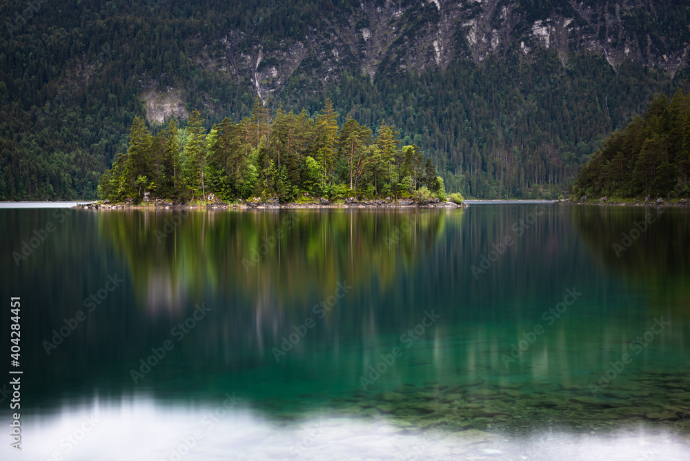 Colorful reflection of Sasseninsel island located at Eibsee lake in the Alps mountains in Bavaria Germany 