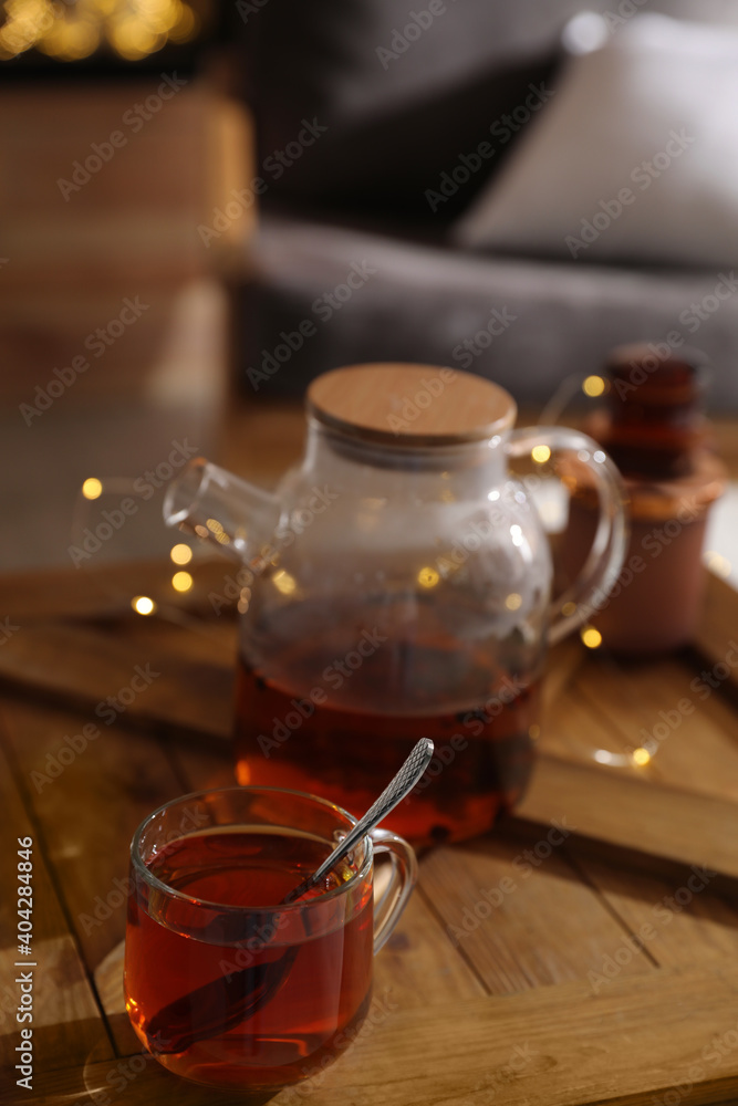 Teapot and cup with hot tea on table indoors Teapot and cup with hot tea on table indoors