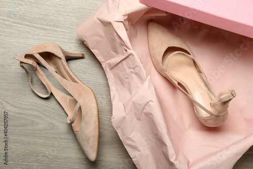 Pair of beautiful shoes and box on wooden background, flat lay © New Africa