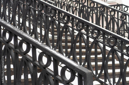 Metal railings and stone steps covered with a thin layer of snow, Shluzovoy pedestrian bridge, Vodootvodny canal, Moscow photo