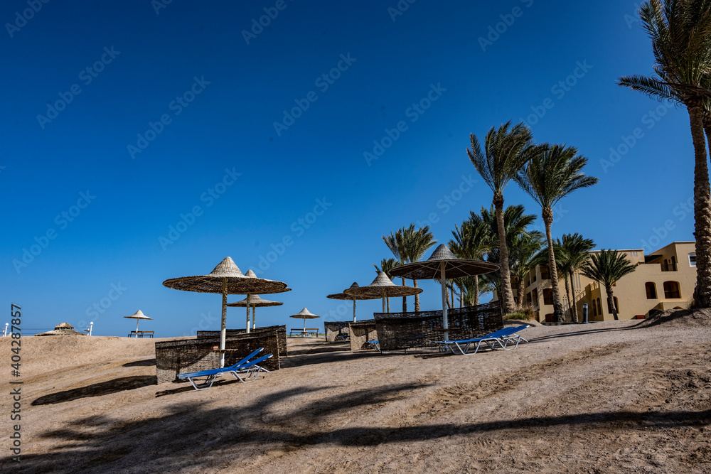 view of a deserted beach on a sunny day with sea and blue sky