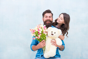 we love each other. teen girl and dad hold tulip bouquet. 8 march or womens day. spring holiday gift. love and family values. happiness. happy family day. father and daughter with flowers and toy