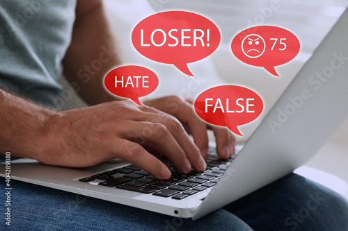 Fotografie Man using laptop and icons with offensive messages, closeup