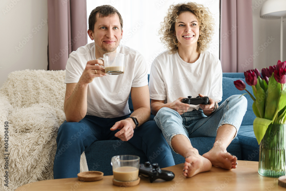 Couple with a gamepads are playing video game console Couple with a gamepads are playing video game console
