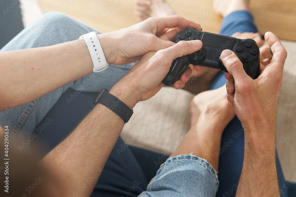 Couple with a gamepads are playing video game console