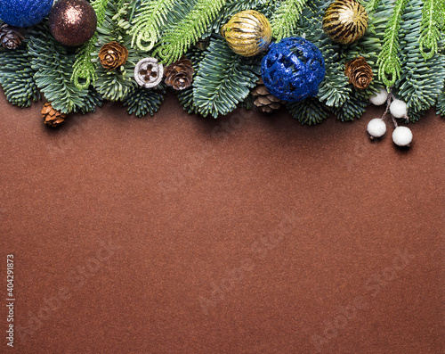 Brown Christmas background. Background with fir branches, cones and toys.