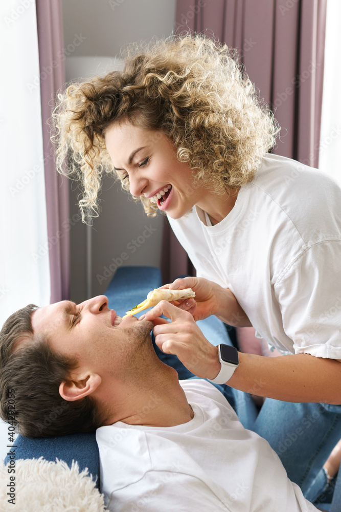 Fototapeta premium Happy couple eating delicious pizza at home