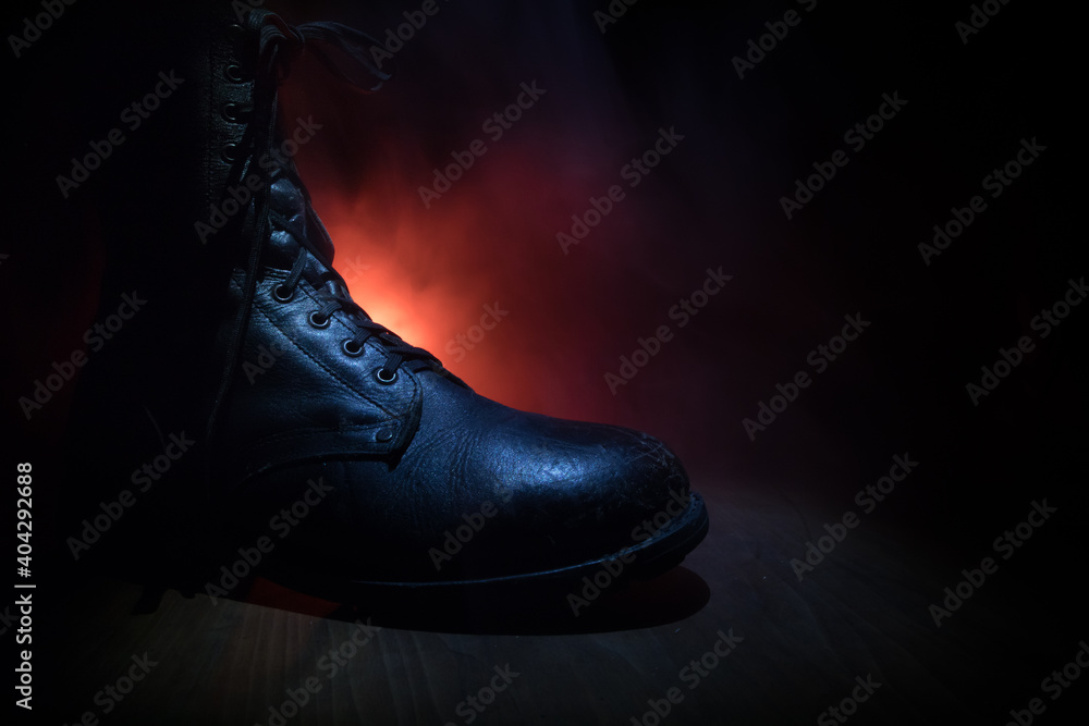 War concept. Old military shoe in a dark toned foggy background. Creative concept of conflict between countries, military aggression.