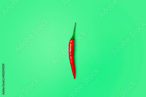 Chili peppers on a colored green background. Red hot chili peppers as an ingredient of Asian and Mexican cuisine and spices