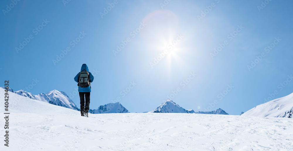 Person mit Blaue Jacke wandert im Schnee in den Bergen