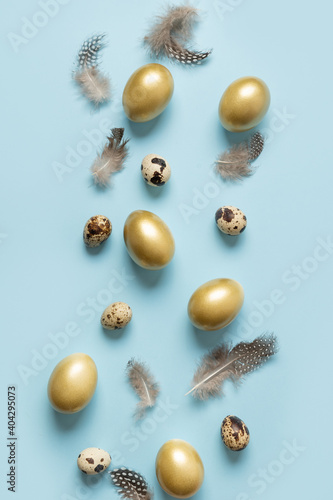 Easter vertical greeting card with decorative golden eggs on blue background. View from above. Flat lay.