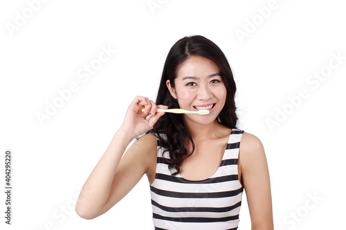 Fototapeta Naklejka Na Ścianę i Meble -  Young woman in a striped dress holding a toothbrush