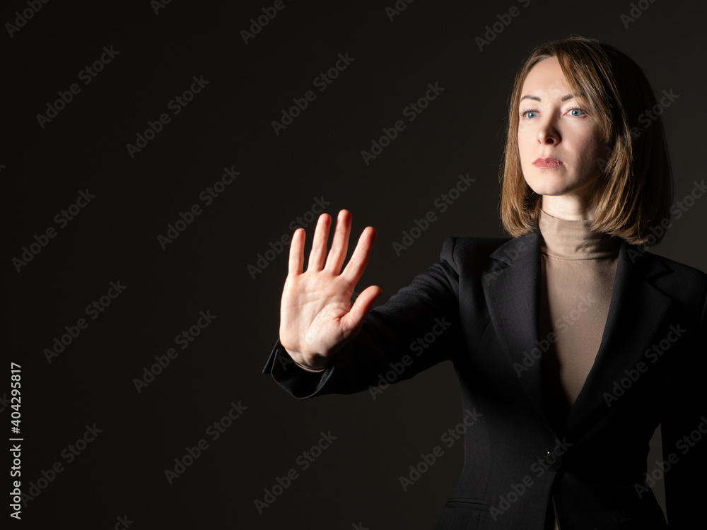 Woman makes stop hand gesture. She calls to stop. Business Woman shows her palm. Office worker calls for a stay onsite. Stop gesture from an office worker. Serious woman orders to stay in place Woman makes stop hand gesture. She calls to stop. Business Woman shows her palm. Office worker calls for a stay onsite. Stop gesture from an office worker. Serious woman orders to stay in place