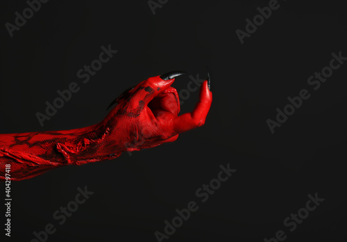 Scary monster on black background, closeup of hand with space for text. Halloween character