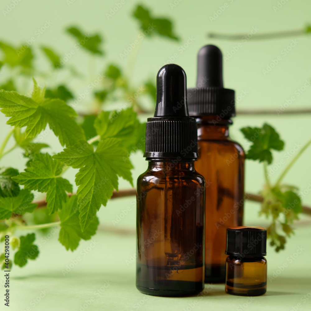 Essential oil falling from a glass dropper on the background of other medications Essential oil falling from a glass dropper on the background of other medications