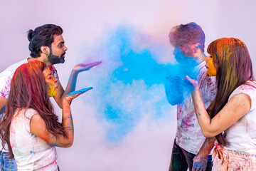 four indian students painted in colors celebrating holi festival in studio white isolate background