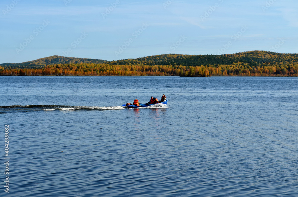 Autumn lake and people in a boat