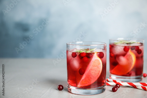 Tasty refreshing cranberry cocktail on grey table. Space for text