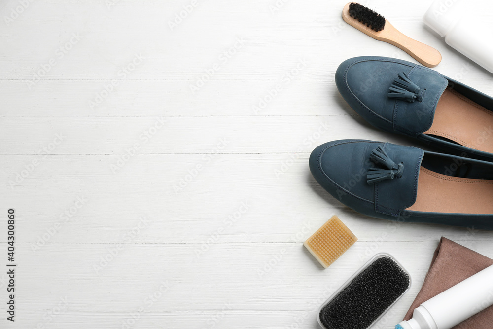 Stylish footwear with shoe care accessories on white wooden table, flat lay. Space for text - obrazy, fototapety, plakaty 