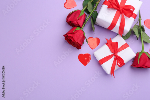 Gift boxes  roses and hearts on violet background  flat lay with space for text. Valentine s Day celebration