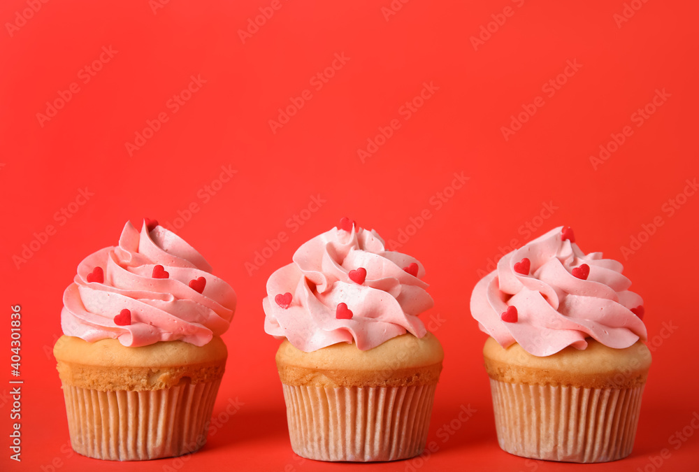 Row of tasty cupcakes on red background, space for text. Valentine's Day celebration