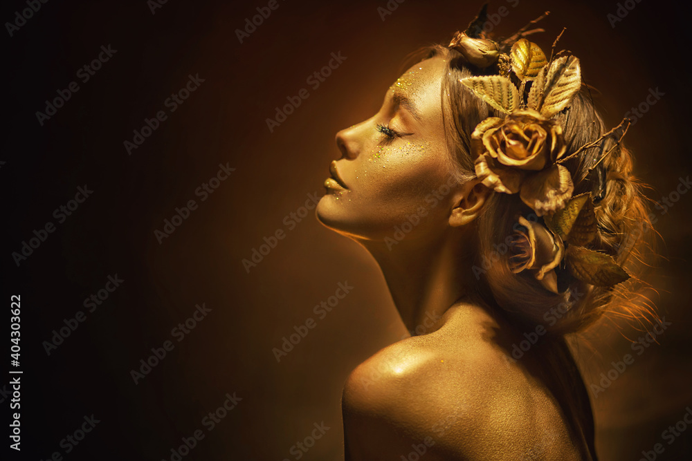 Portrait Closeup Beauty fantasy woman, face in gold paint. Golden shiny skin. Fashion model girl, image goddess. Glamorous crown, wreath roses, jewellery accessories. Professional metallic makeup
