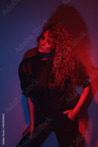 Young and sexy woman with a stylish Afro hairstyle wearing leather biker suit