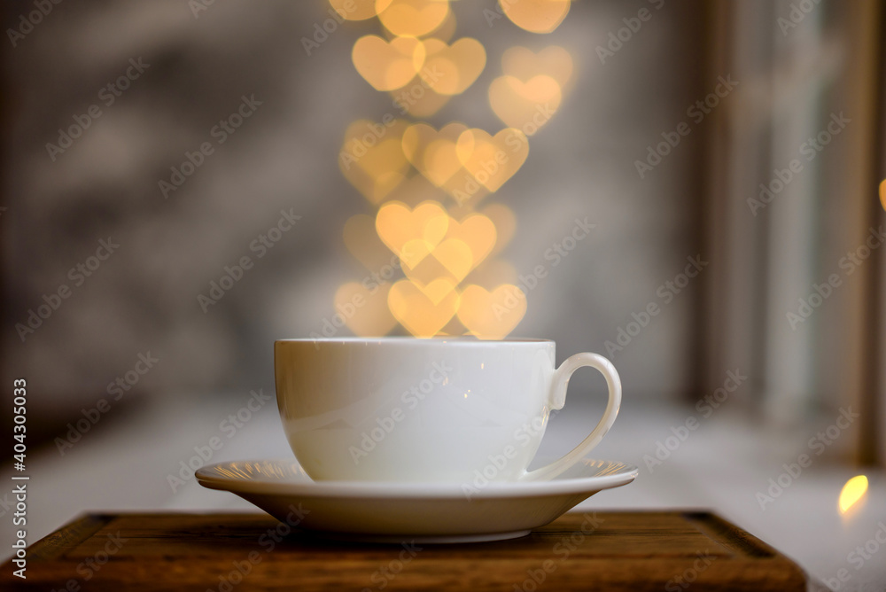 A cup with a hot invigorating morning drink with lights in the form of hearts A cup with a hot invigorating morning drink with lights in the form of hearts