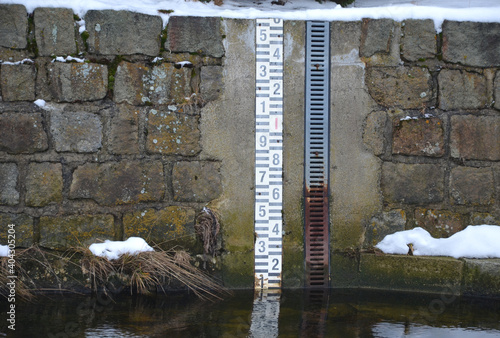 level measuring device on the creek and river. during floods, it determines decreases and increases in the levels of meteorological and hyrological statistics. numerical scale on the waterfront wall photo