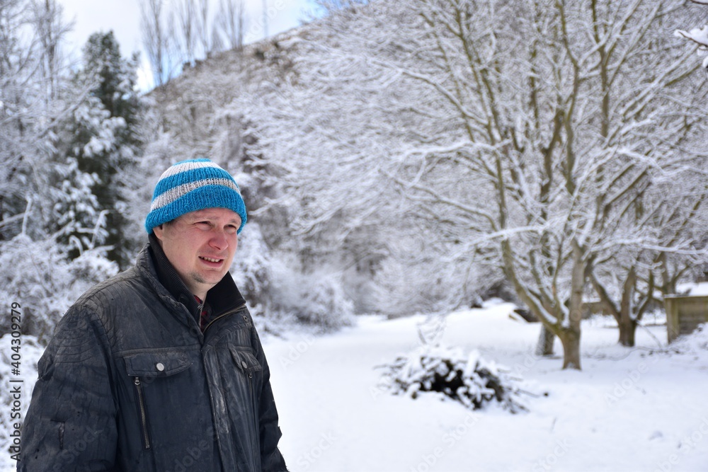 Portrait of man with cold face, dressed in old and torn jacket and blue and white wool cap in snowy mountain area. Temporary Filomena. Portrait of man with cold face, dressed in old and torn jacket and blue and white wool cap in snowy mountain area. Temporary Filomena.