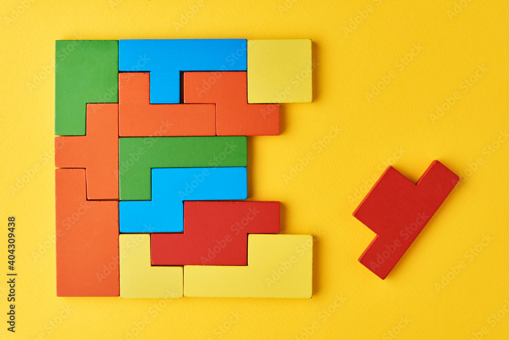 Fototapeta premium Logical thinking concept. Different shapes colorful wooden blocks on white background