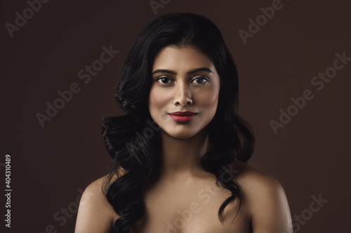Obraz na plátně Indian woman with beautiful makeup and hairstyle on brown background