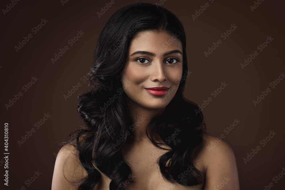 Fototapeta premium Indian woman with beautiful makeup and hairstyle on brown background