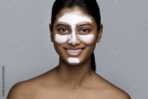 Young indian woman with a cleansing mask applied on her face
