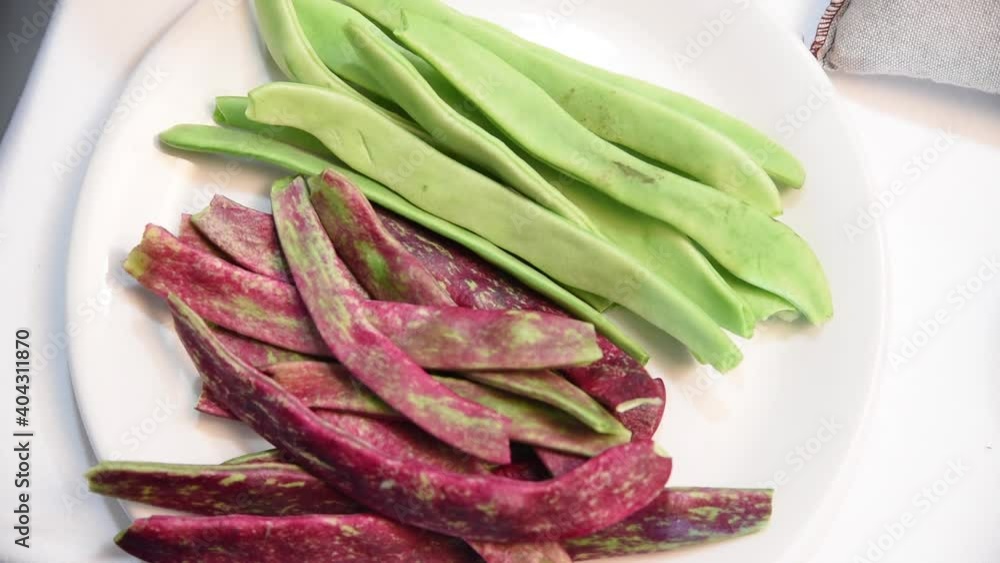 A plate of green and red beans ready to cook. A white plate with green beans. Paella ingredients A plate of green and red beans ready to cook. A white plate with green beans. Paella ingredients