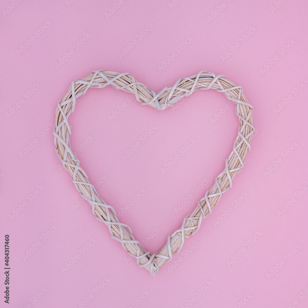Creative minimal concept with heart symbol made of twigs on pastel pink background. Flat lay design