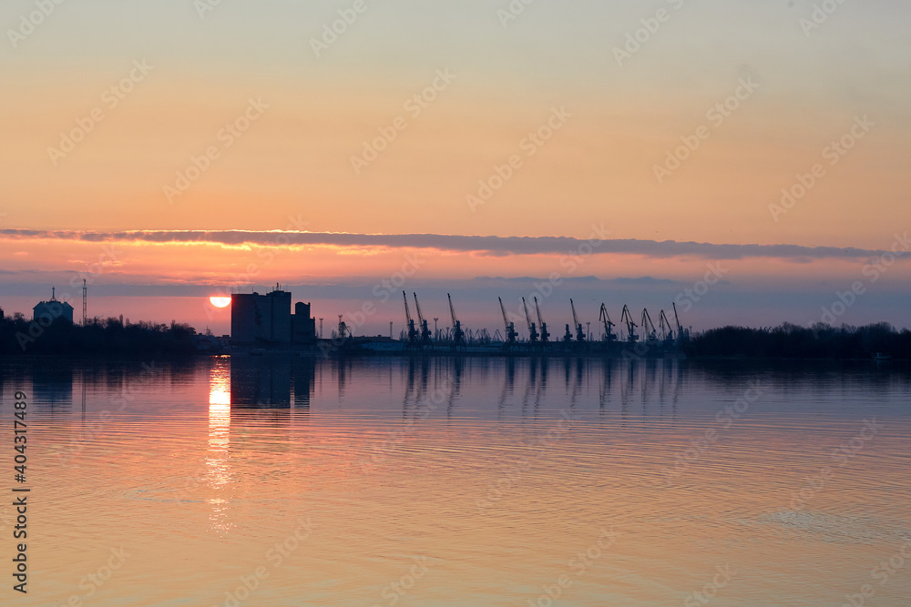 View over the Danube river at port cranes at winter sunrise