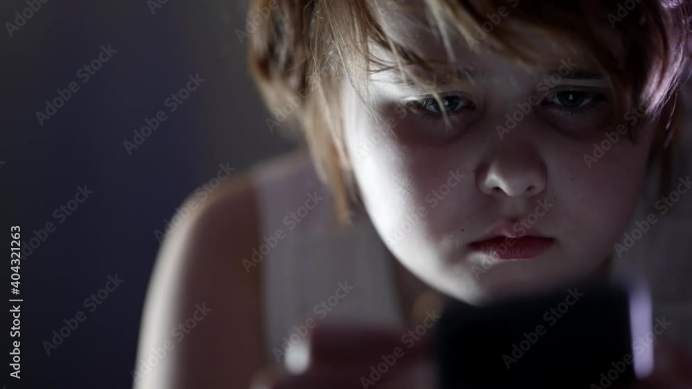 little girl with internet game addiction is playing smartphone at night, closeup little girl with internet game addiction is playing smartphone at night, closeup