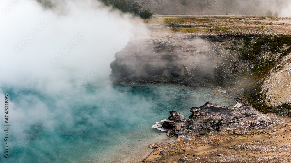Rising steam from blue thermal lagoon in yellowstone antional park in america