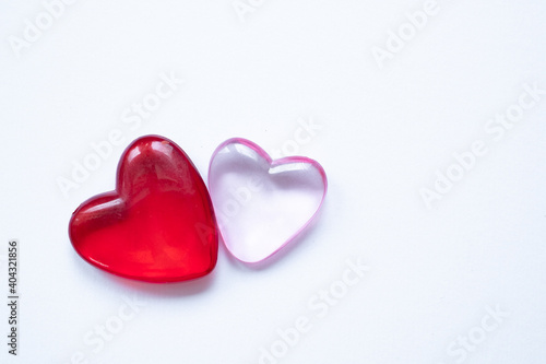 Valentine's day background with two hearts. Shiny glass hearts on white background.