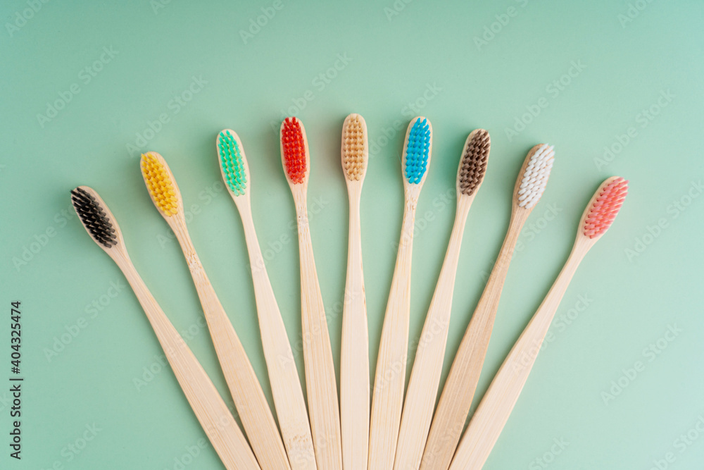 A set of Eco-friendly antibacterial toothbrushes made of bamboo wood on a light green background. Environmental care trends A set of Eco-friendly antibacterial toothbrushes made of bamboo wood on a light green background. Environmental care trends