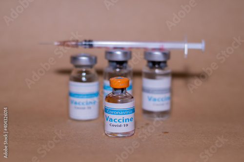 vaccine for covid-19. Syringe and coronavirus vaccine bottle on yellow background. covid19 vaccine