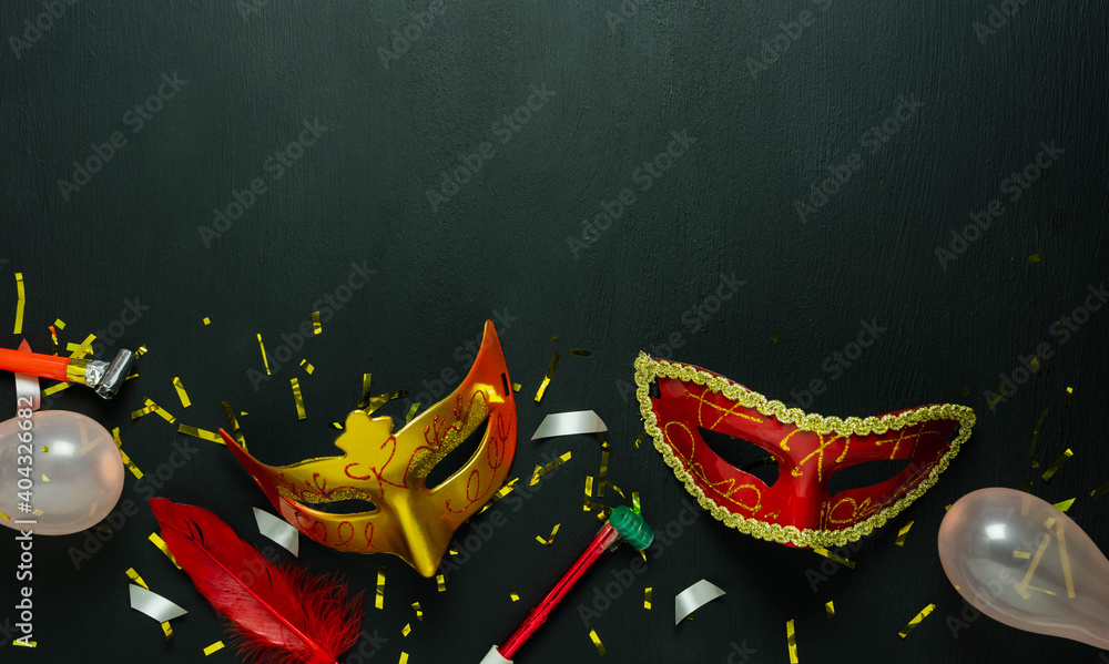 Table top view aerial image of beautiful colorful carnival festival background.Flat lay accessory object the several mask  decor confetti on modern black wooden at home office desk studio.copy space.