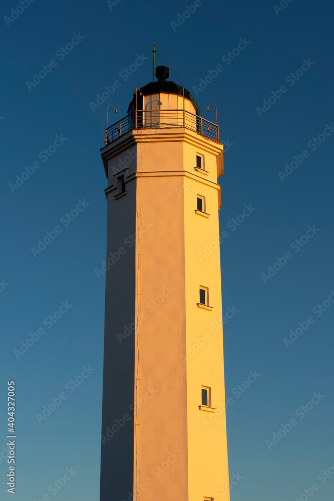Lighthouse on sunset sky, summer time