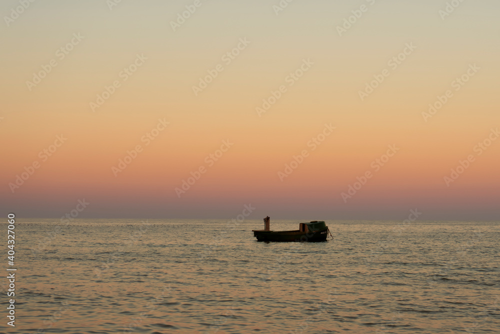 Alone fisherman boat on sunset in Black Sea
