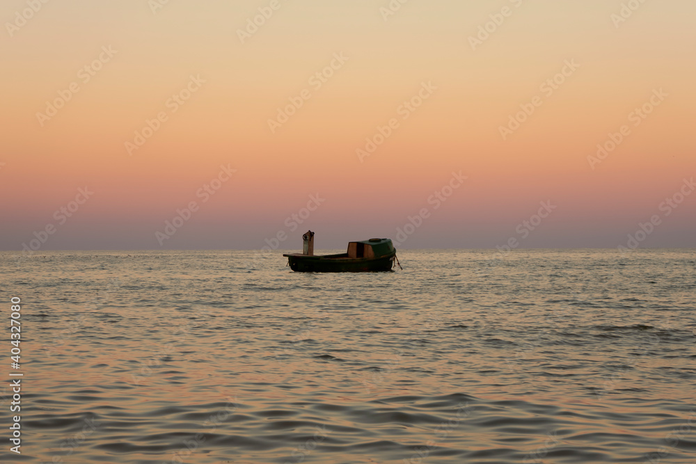 Alone fisherman boat on sunset in Black Sea
