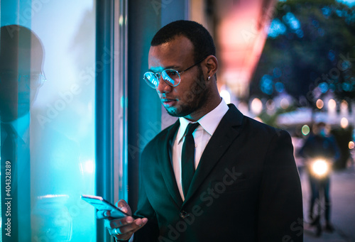 Young man dressed elegantly with his mobile phone at night.