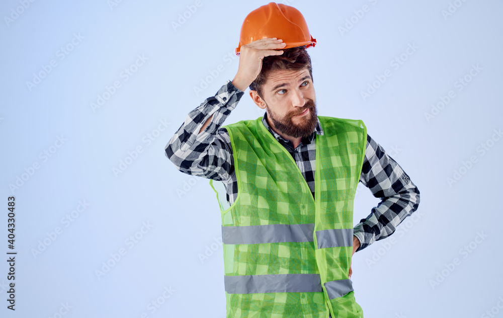 Cropped view of a civil engineer in a reflective vest and a scythe on a blue background